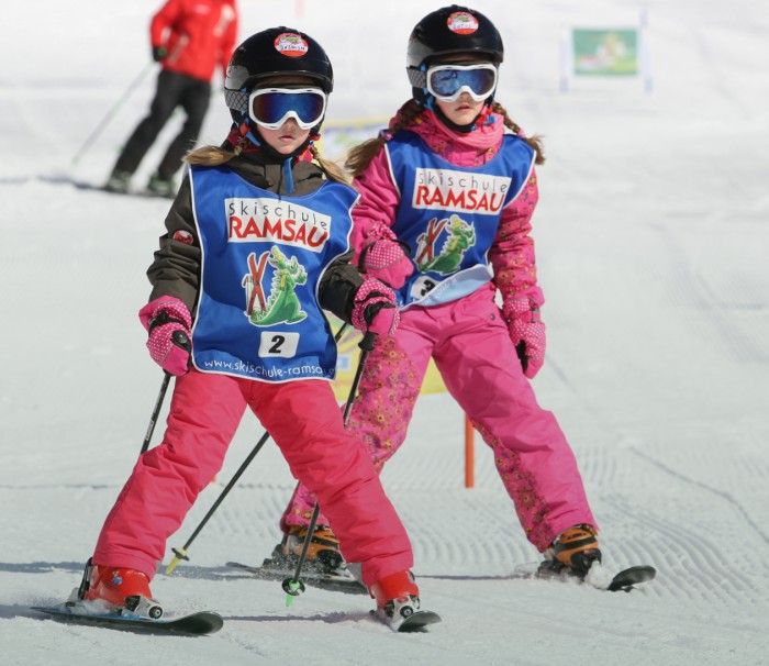 Zwei Kinder lernen Skifahren auf der Skipiste am Rittisberg