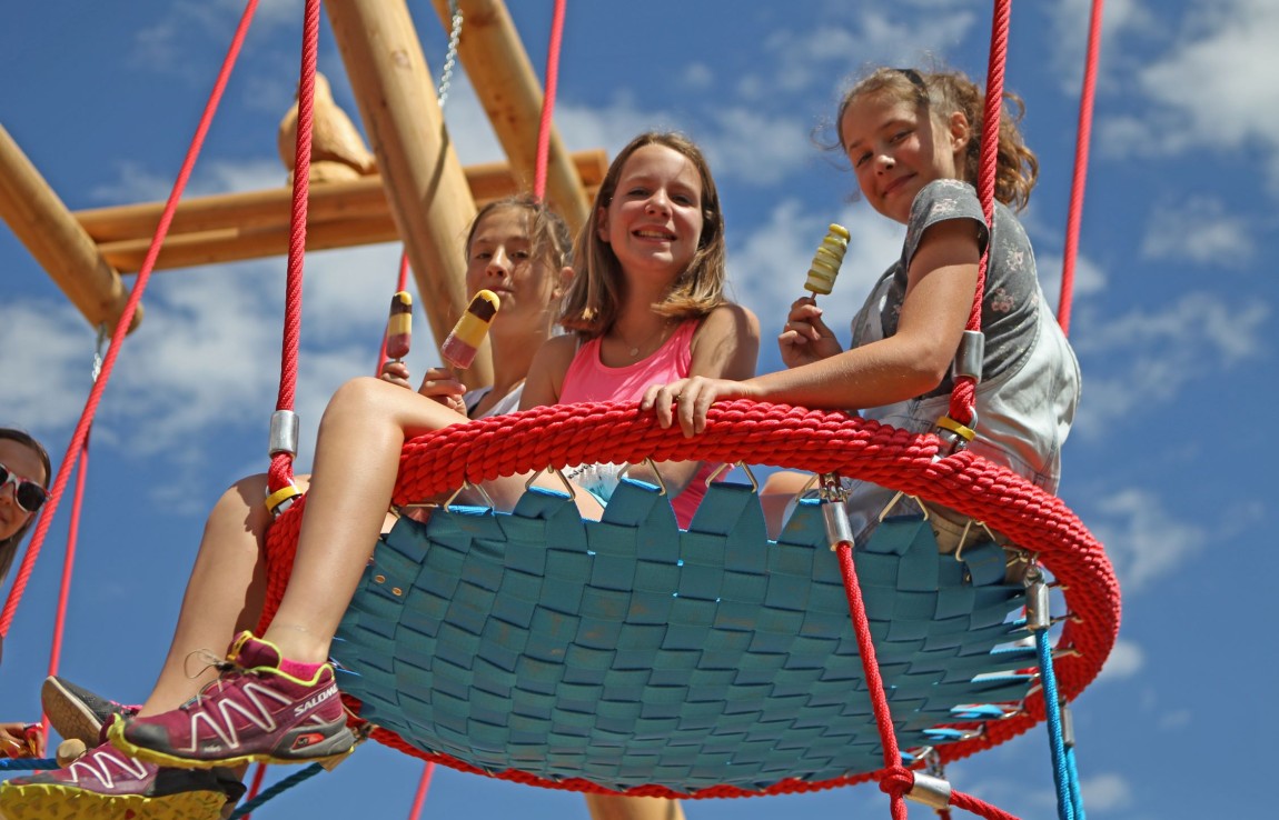 Kinder schaukeln am Höhenspielplatz Rittisberg in Ramsau am Dachstein