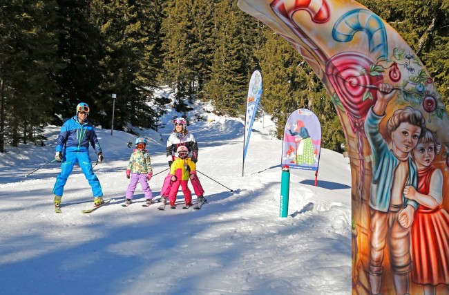 Familie mit Kindern fährt Ski am Märchenabfahrt 